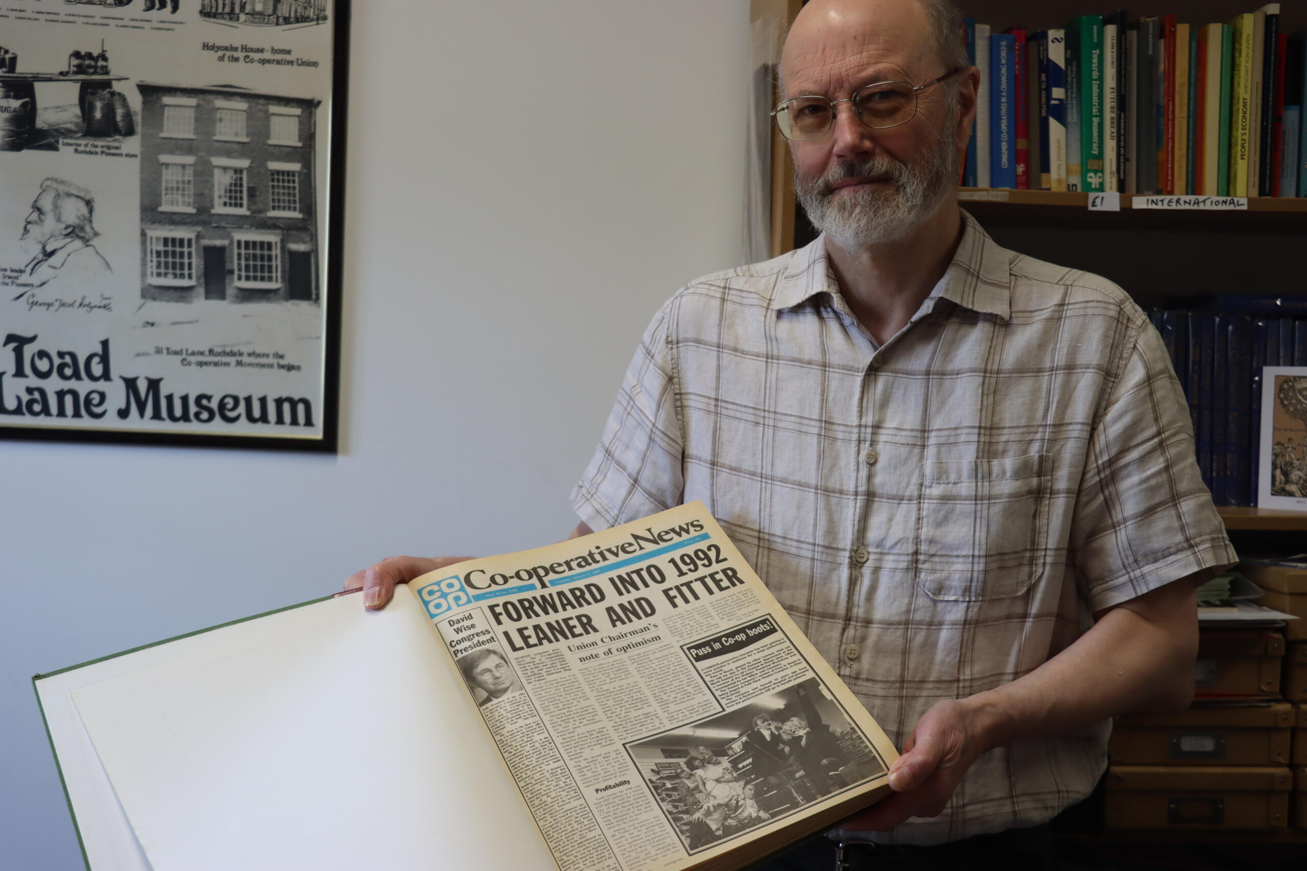 Steve Thompson holding a bound volume of Co-operative News